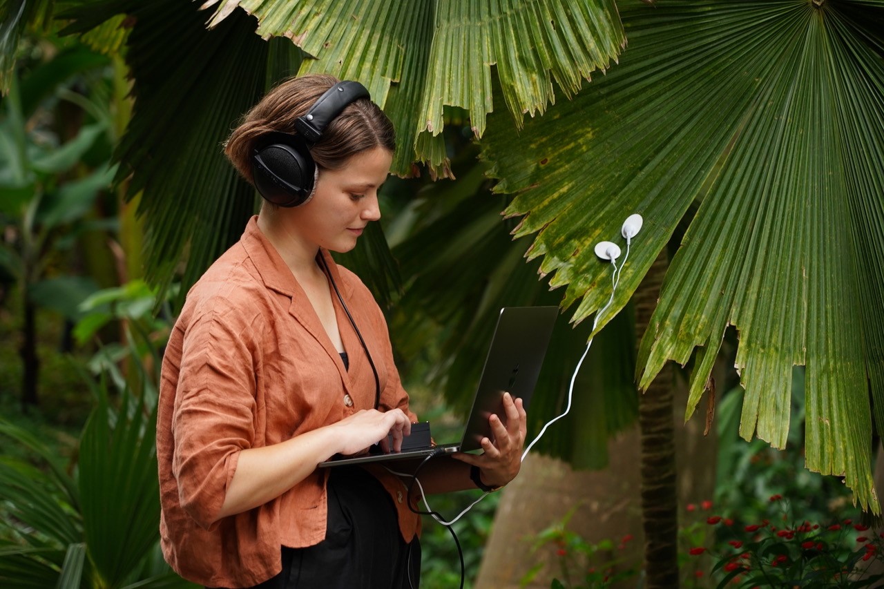 Photograph of Alice Boyd against a backdrop of tropical plants, taken at the Eden Project