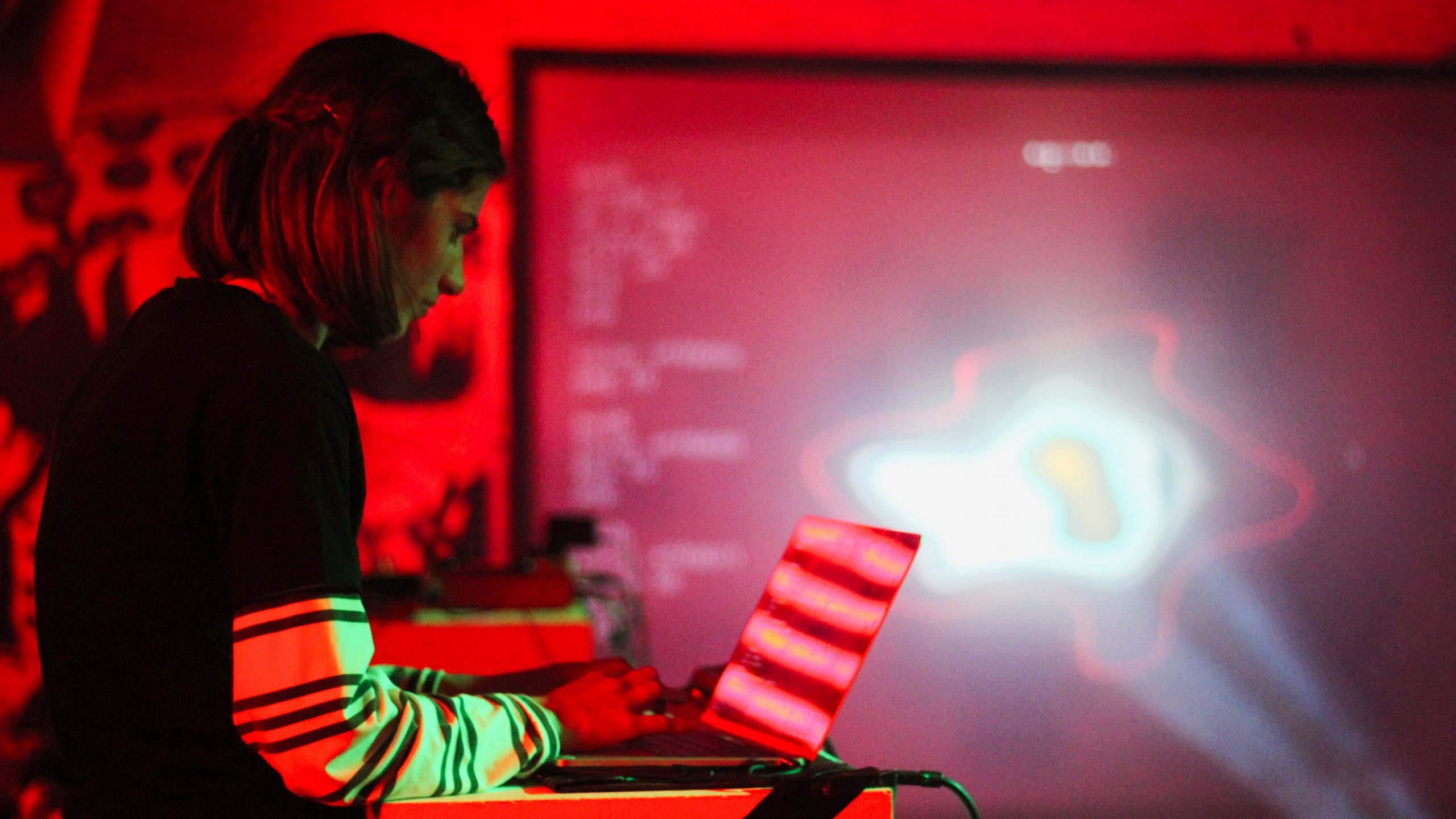 Lizzie Wilson (young woman with brown hair) live-coding on a computer
