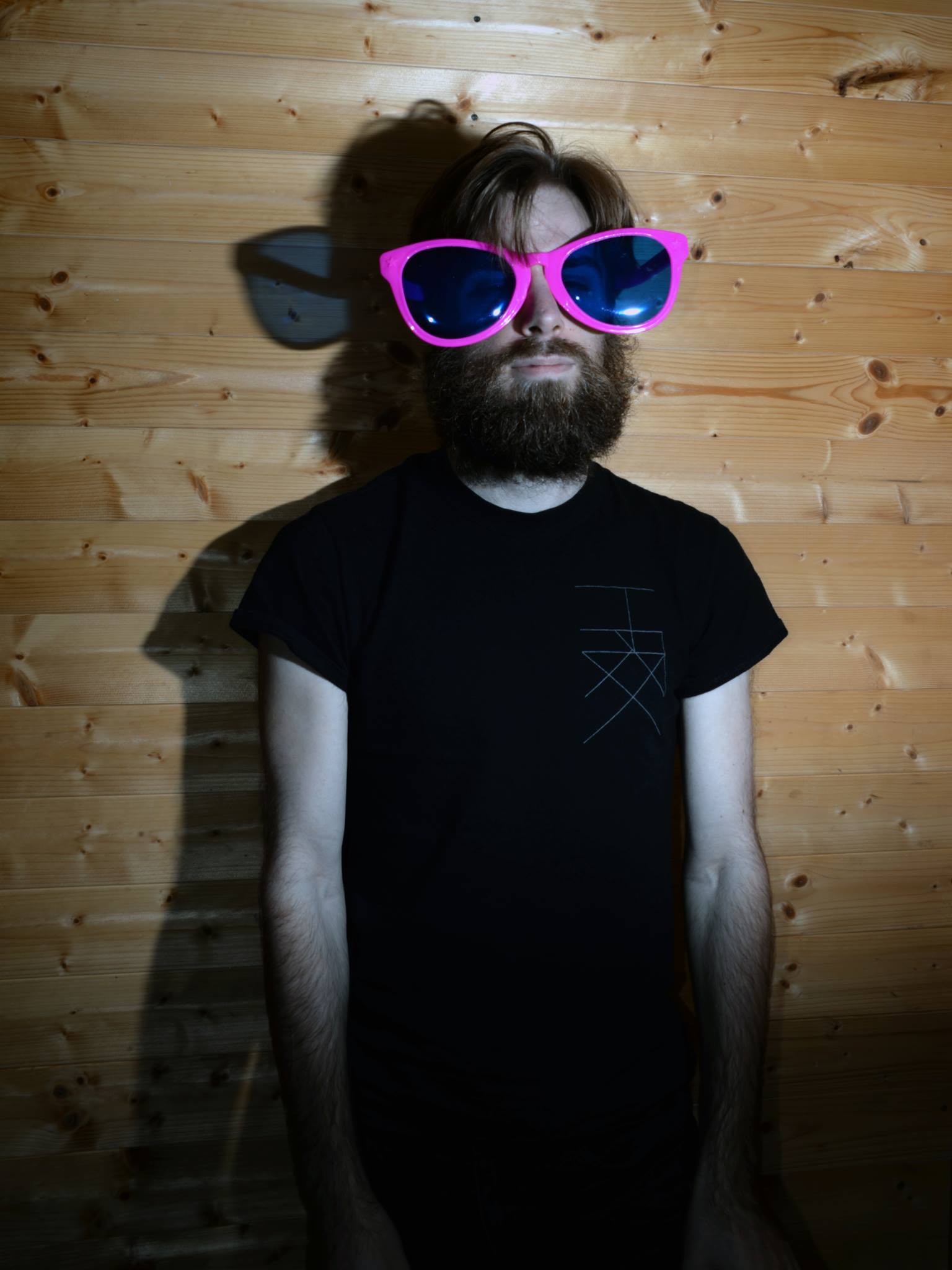 Photo of Simon Paton in a black shirt waring large pink sunglasses